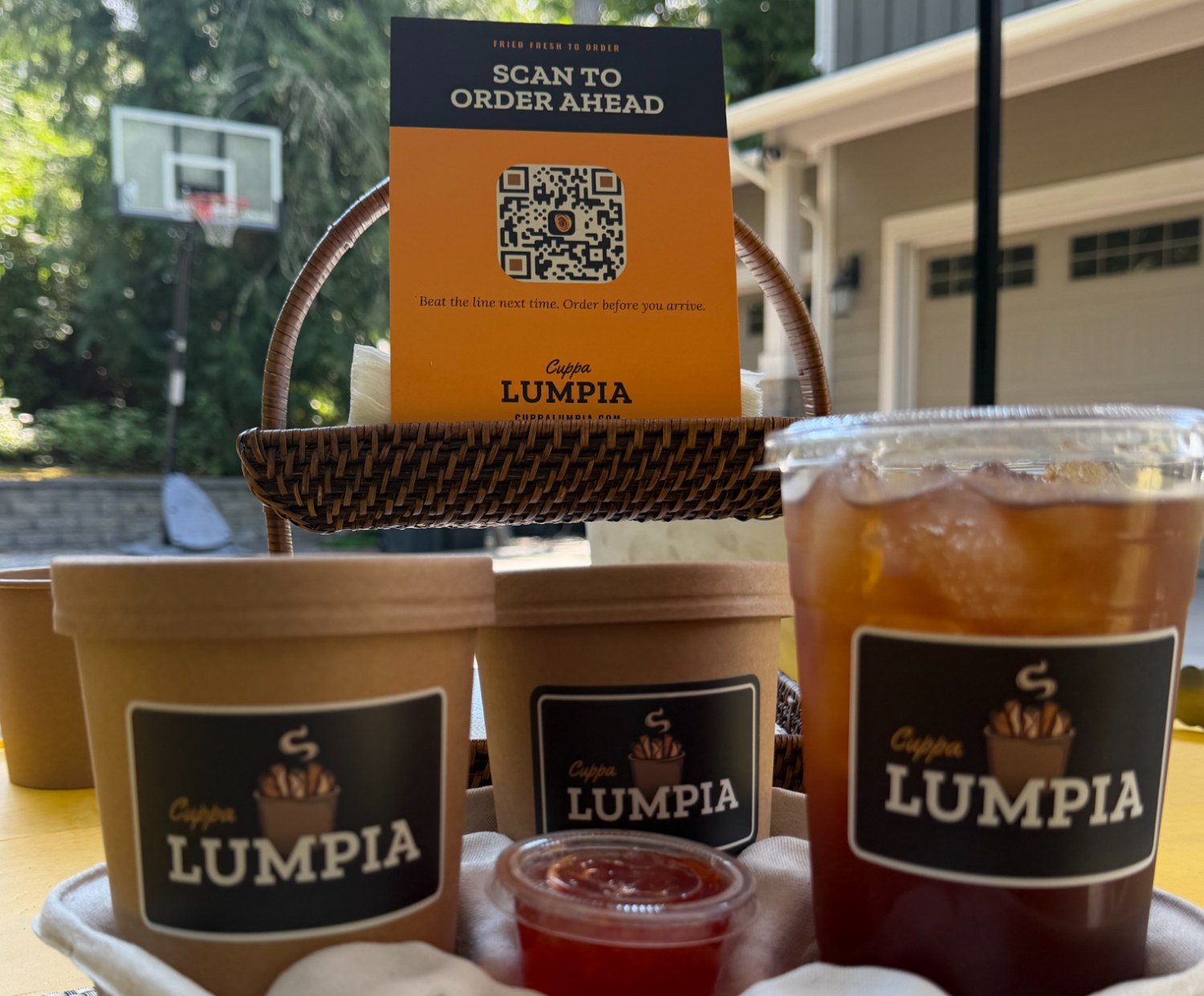 Cuppa Lumpia branded cups and iced drink in front of the Scan to order ahead sign at the stand