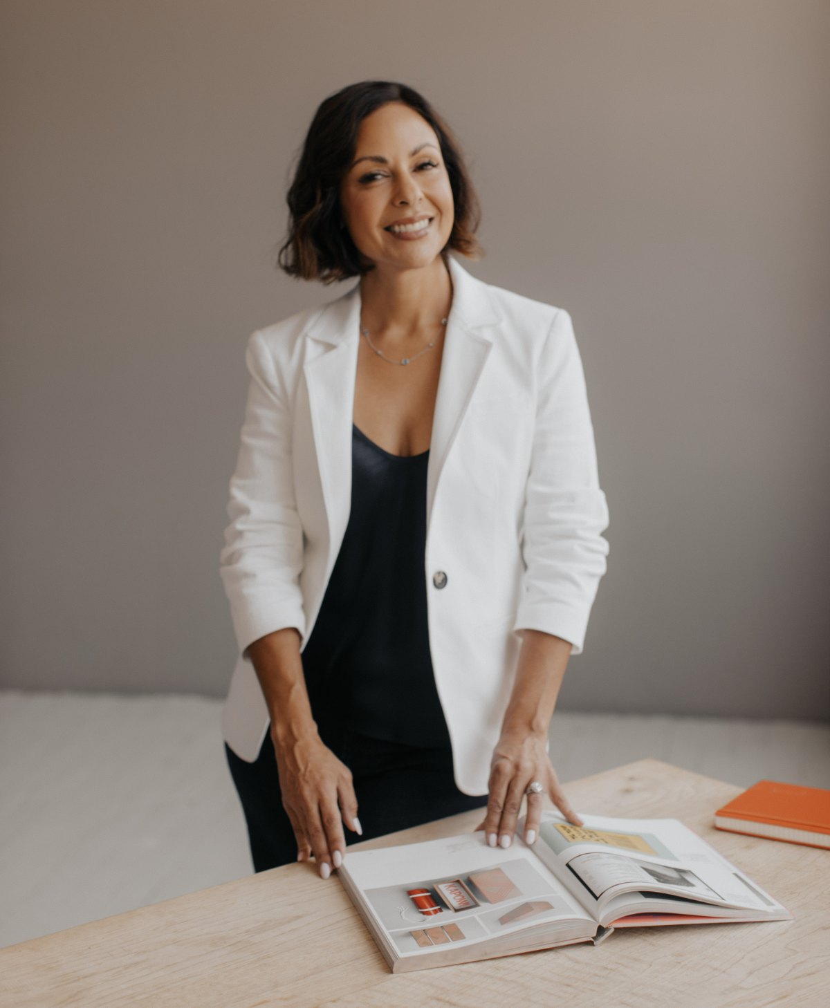 Nicole Mi&ntilde;oza at a table with an open design book