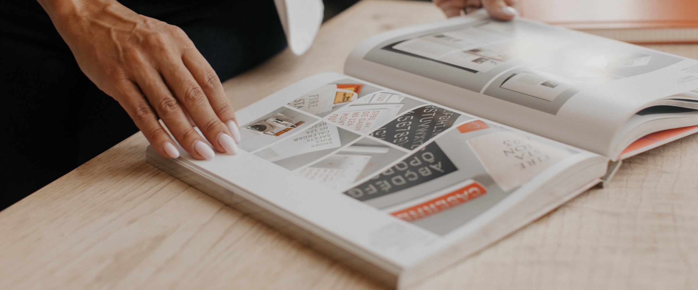 Nicole's hands turning the pages of a type specimen book
